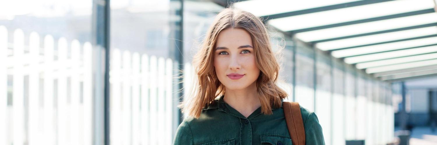 Femme qui sourit avec un portable à la main Femme qui sourit avec un portable à la main