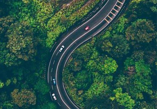Route sinueuse traversant une forêt vue du ciel